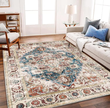 Distressed vintage area rug with blue and orange oriental patterns in a modern living room setting.