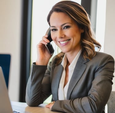a woman in a suit and tie smiling while talking on a cell phone