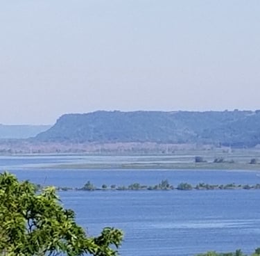 a wide river with a bluff in the background