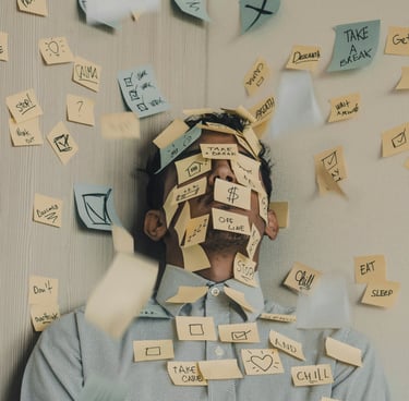 Gestresster Mann hat zu viele Aufgaben auf Post It Zetteln.