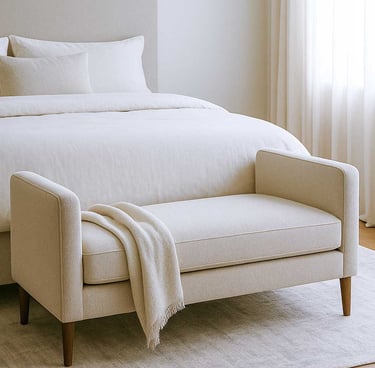 mall bench sofa at the foot of a bed in a cozy, modern bedroom with soft lighting and layered neutral textures.
