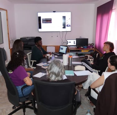 A diverse group of women sitting around a conference table during a collaborative business workshop or meeting.