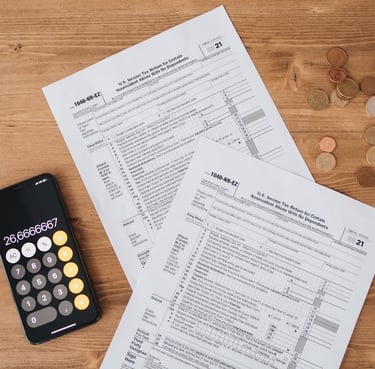 calculator, money, and tax return sheet all symbolizing tax advantages gold ira can have