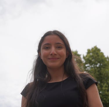 a woman in a black dress standing in front of a tree qui est adhérente de néoléa
