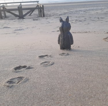 ceramic figurine walking on the sand of a beach