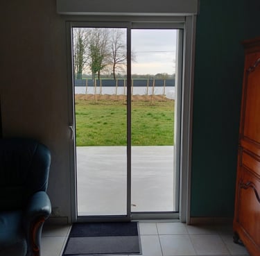 porte coulissante en pvc blanc donnant sur jardin posée par l'artisan menuisier en Vendée