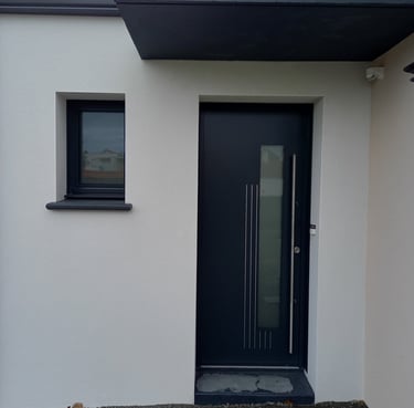 porte d'entrée en pvc noire et fenêtre en pvc noire sur maison neuve posée par l'artisan menuisier 