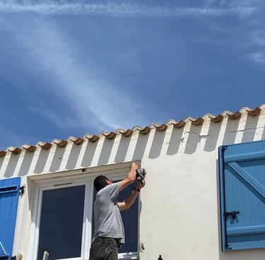 artisan menuisier qui pose un volet sur une maison en Vendée