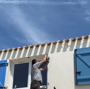 artisan menuisier qui pose un volet sur une maison en Vendée