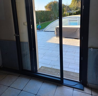 porte coulissante en pvc noire donnant sur jardin posée par l'artisan menuisier en Vendée