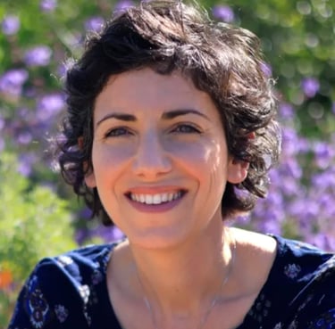 Jane Sterken smiling in field of flowers
