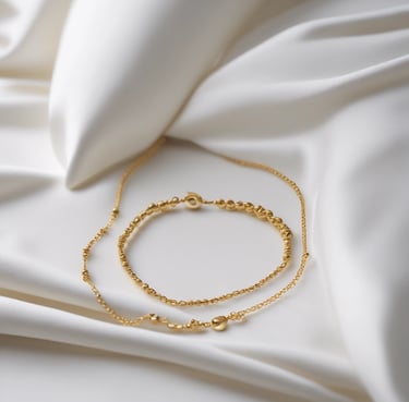 Close-up of delicate gold jewelry resting on a cream linen fabric.