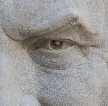 Extreme close-up of the eye of a relief of a man carved in white Macael marble.