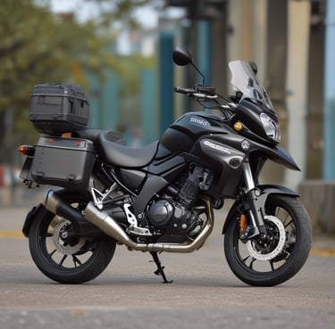 A custom motorcycle with a rugged appearance is parked on a dirt path. The bike is designed with a matte black paint job, featuring a branded logo of 'Cafe Racer'. It is equipped with dual front suspensions, a circular headlamp with grill protection, and handlebars extending outward. The background includes residential buildings and some trees.