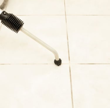 cleaning a tile floor with a brush/wand