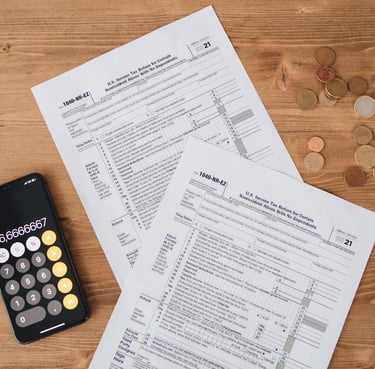 calculator, money, and tax return sheet all symbolizing tax advantages gold ira can have
