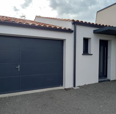 porte de garage noire avec porte intégrée et porte d'entrée en pvc posée par l'artisan menuisier