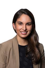 a woman in a brown jacket and black top