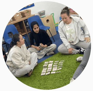 a group of learners sat on the floor completing an exercise using cards