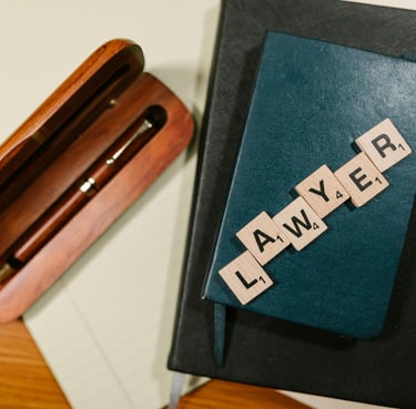 una caja de madera con un bolígrafo y unas letras de juego diciendo lawyer