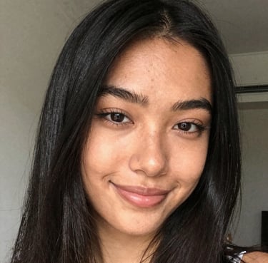 A stylish Gen Z girl smiling confidently during her pre-shoot session, looking like she is on a fashion shoot. Her makeup is flawless, and the lighting is professional studio-quality but warm. Brand color #A65E4E in her accessories.