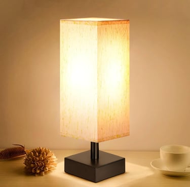 Modern square bedside table lamp with a rectangular beige fabric shade and a black metal base.