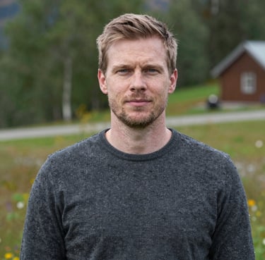 A smiling customer shaking hands with a mechanic inside Autofix Garage, with a repaired car in the background.
