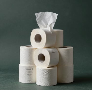 A minimalist studio shot of a stack of Dalisay 100% virgin pulp tissue rolls, glowing under soft light against a dark slate green background, highlighting their purity.