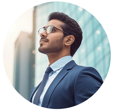 Professional businessman in a blue suit and glasses looking up confidently in front of a city building.
