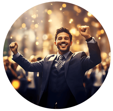 Smiling businessman in a suit celebrating success with raised fists under golden lights.