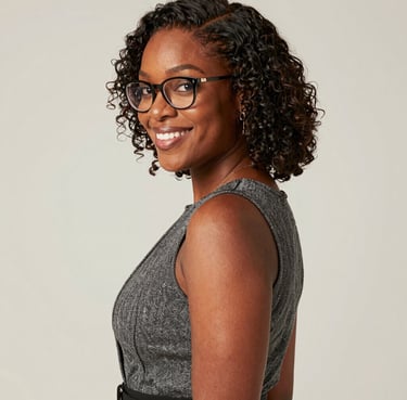 Smiling woman working on a laptop in a modern office environment.