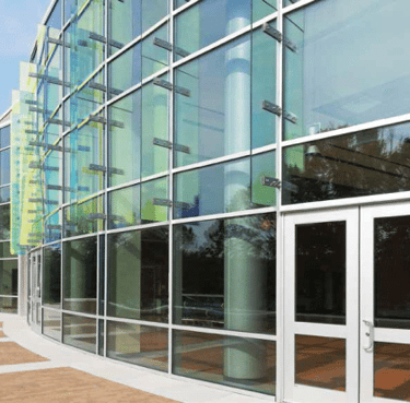 a building with a glass wall and a clock on the outside
