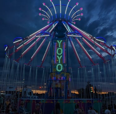 a carnival ride at night with people sitting on chairs