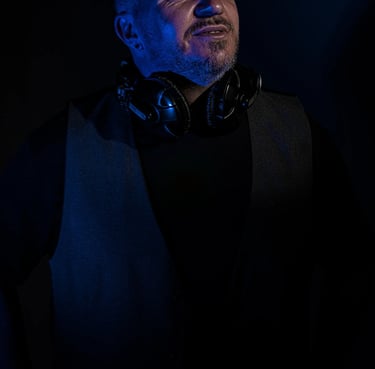 Künstlerporträt eines DJs mit Kopfhörern und kreativem Lichteffekt in Blau, Studioaufnahme Berlin.