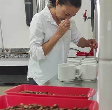 a woman in a white shirt and red trays of chocolate covered with chocolate