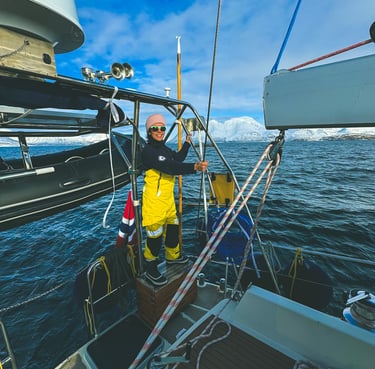 a woman in yellow on a sailing boat adventure in Norway | Jolly Good Times Sailing