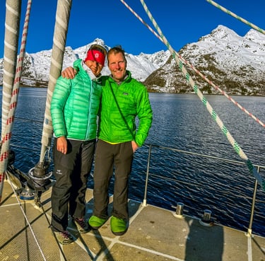 a couple standing on a sailing yacht in a ski and sail advenure in Norway | Jolly Good Times Sailing