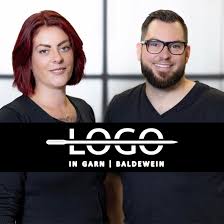 a man and woman standing in front of a logo