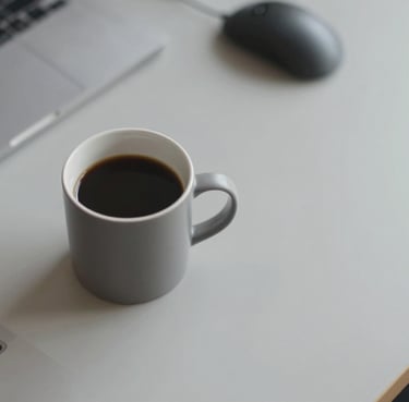 A top-down view of a designer's workspace featuring a coffee cup and high-end tech accessories on a light gray #E0E1DD desk. The style is inviting and modern.