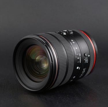 Close-up of a high-end camera lens on a black surface with subtle reflections in dark gray. Sharp focus under professional lighting. International / Professional.