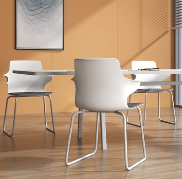 Stackable white meeting chairs with arms around a round table in bright office space