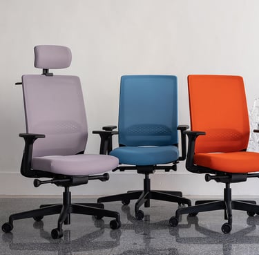 Three ergonomic office chairs in purple, blue, and orange on castors with armrests