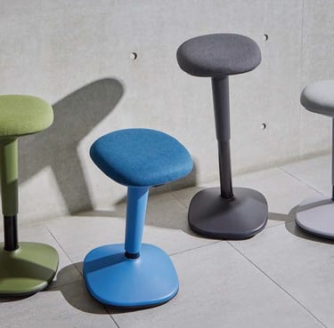 Upholstered motion stools in blue, grey, green with rounded seats and weighted bases