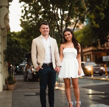 a man and woman holding hands and walking down the street