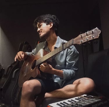 a man sitting on a couch playing guitar
