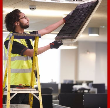 Técnico realizando mantenimiento de aire acondicionado en oficina de Valencia