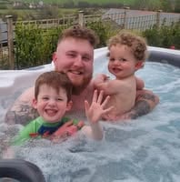 a man and two children in a hot tub