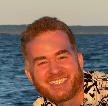a happy custom sailboat charter customer smiling man with a beard and a shirt on