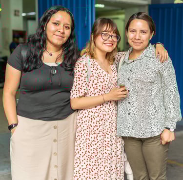 three women standing next to each other in a warehouse