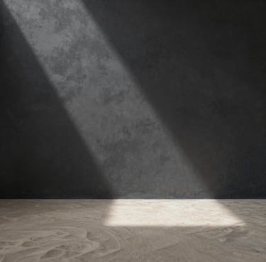Interior architectural space, wide shot, ray of light hitting a textured charcoal wall, soft sand floor, zen-like peace #F9F7F2 #333333